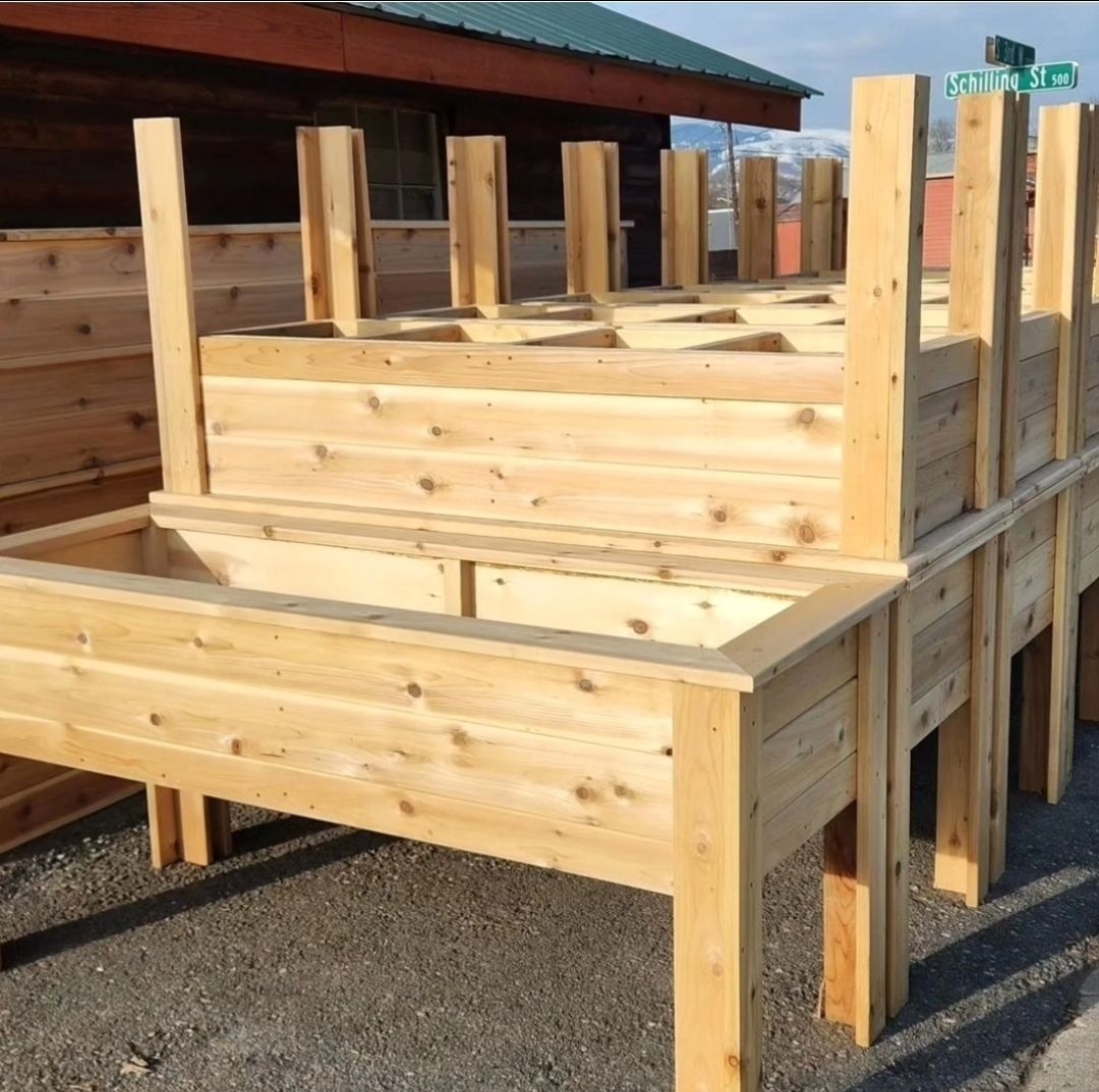 A row of wooden planters are lined up in front of a building.