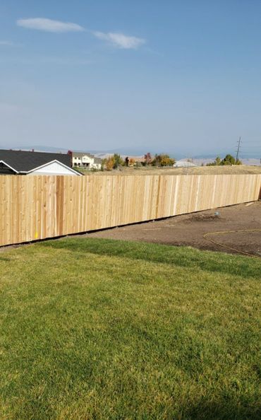 A wooden fence is sitting in the middle of a lush green field.