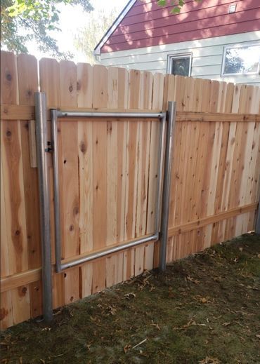 A wooden fence with a metal gate attached to it.