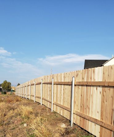 A long wooden fence is sitting in the middle of a field.
