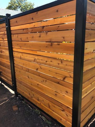 A wooden fence with a black metal frame.