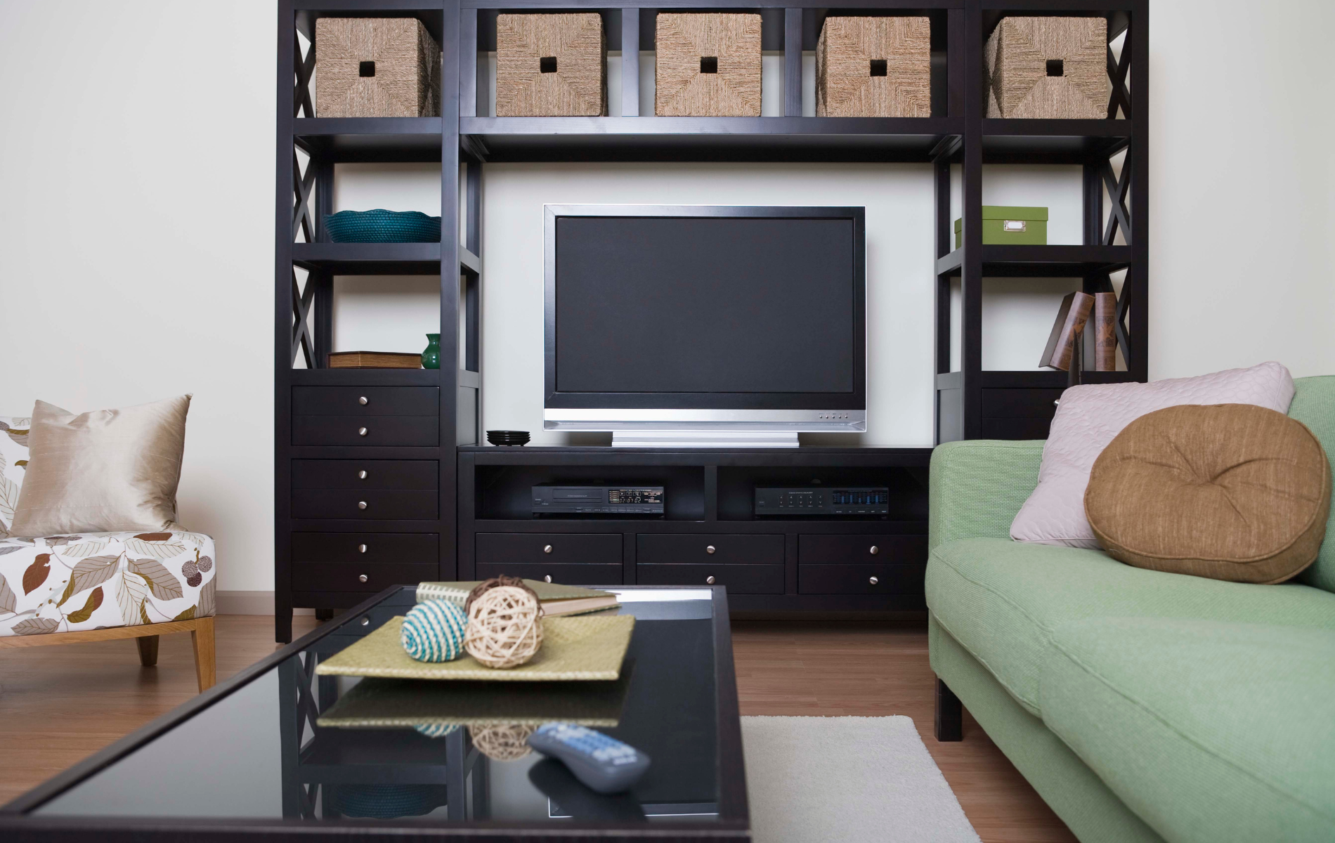 A living room with a green couch and a flat screen tv