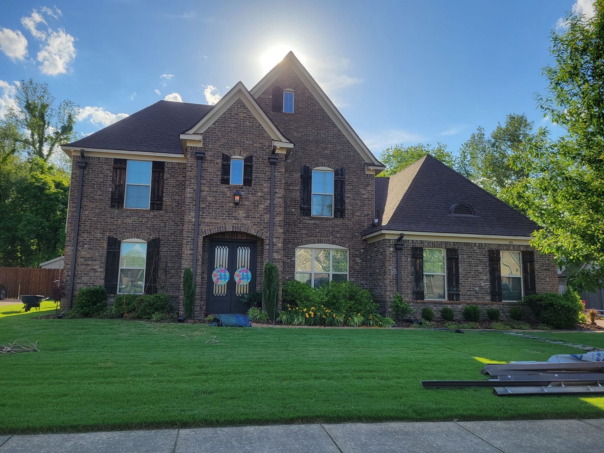 A large brick house with a lush green lawn in front of it.