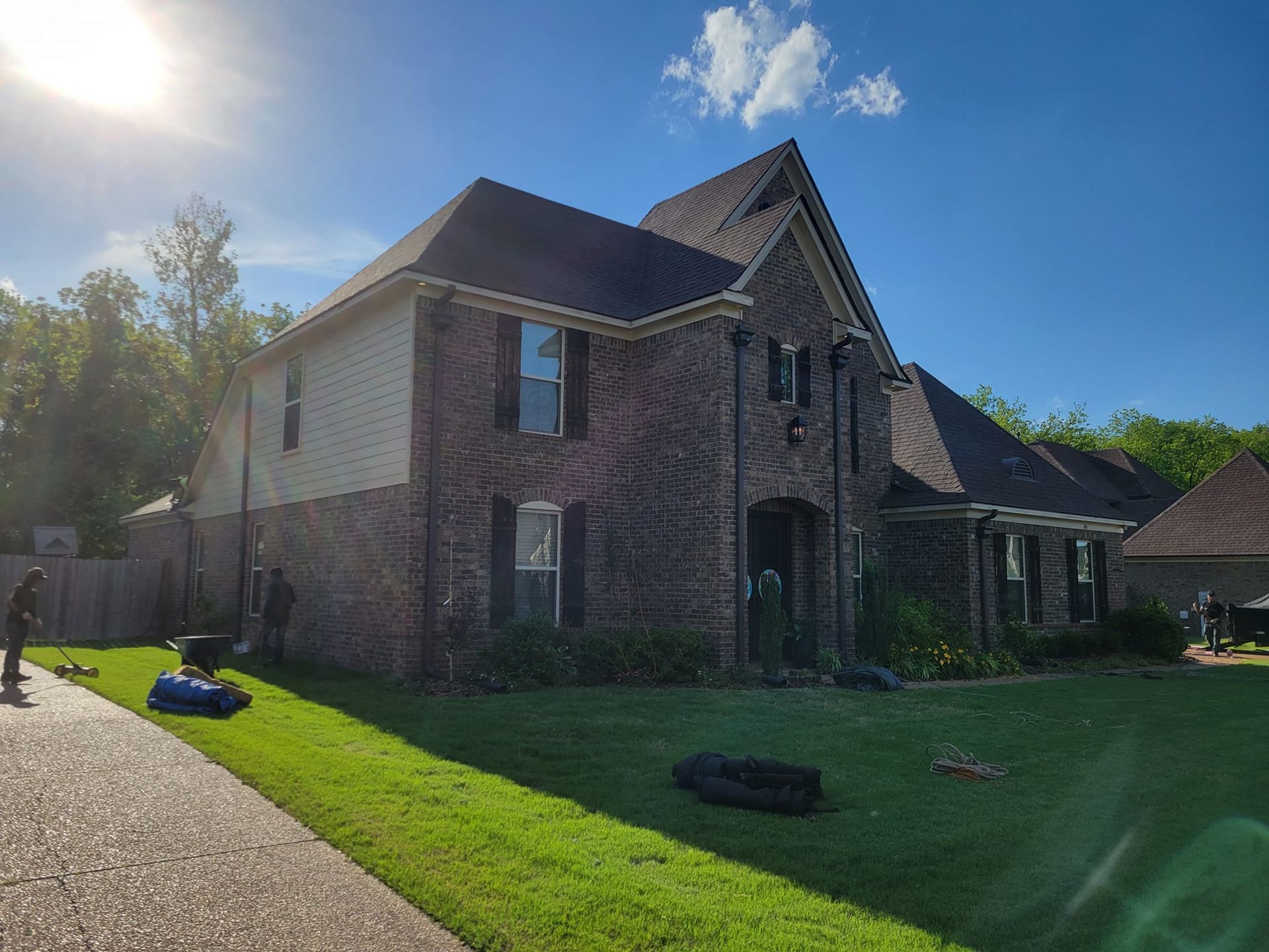 A large brick house with a lawn mower in front of it.