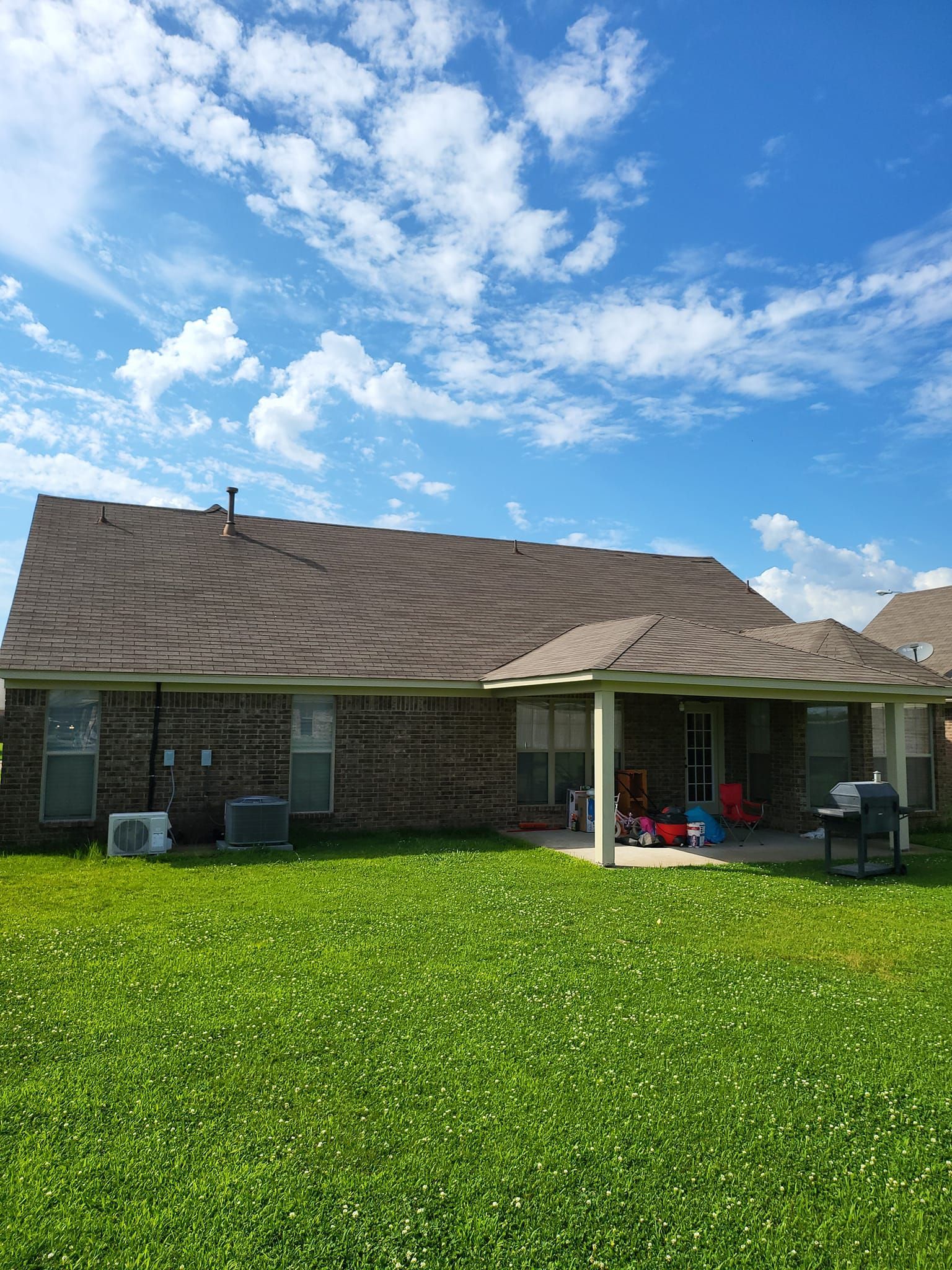 The back of a house with a large lawn in front of it.