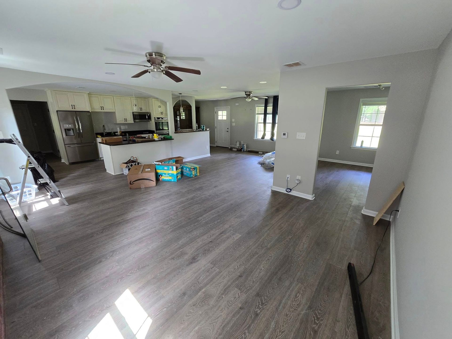 A living room with hardwood floors and a ceiling fan.