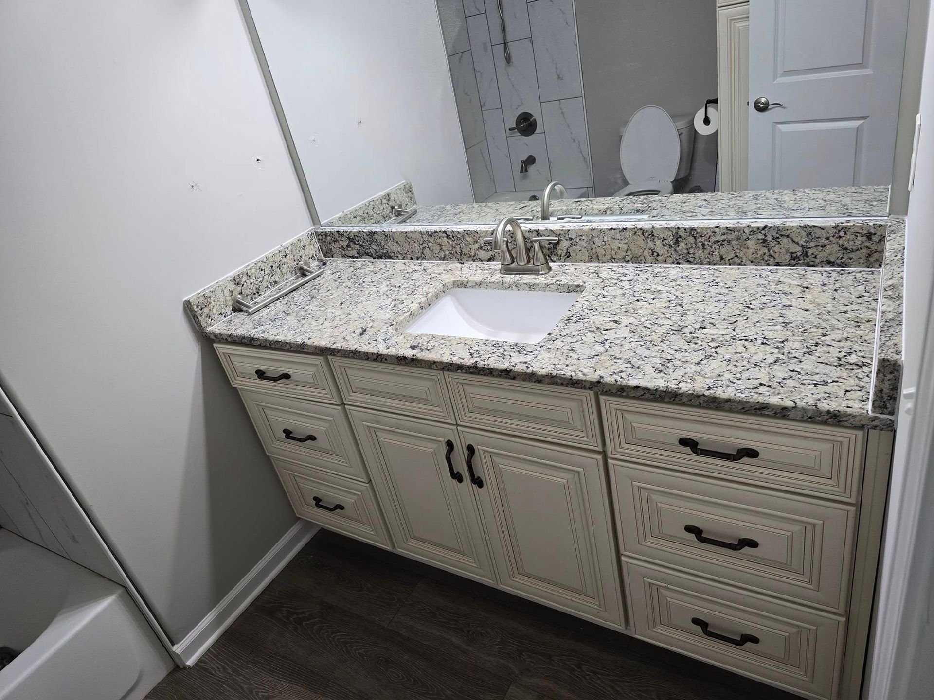 A bathroom with a sink , mirror and toilet.