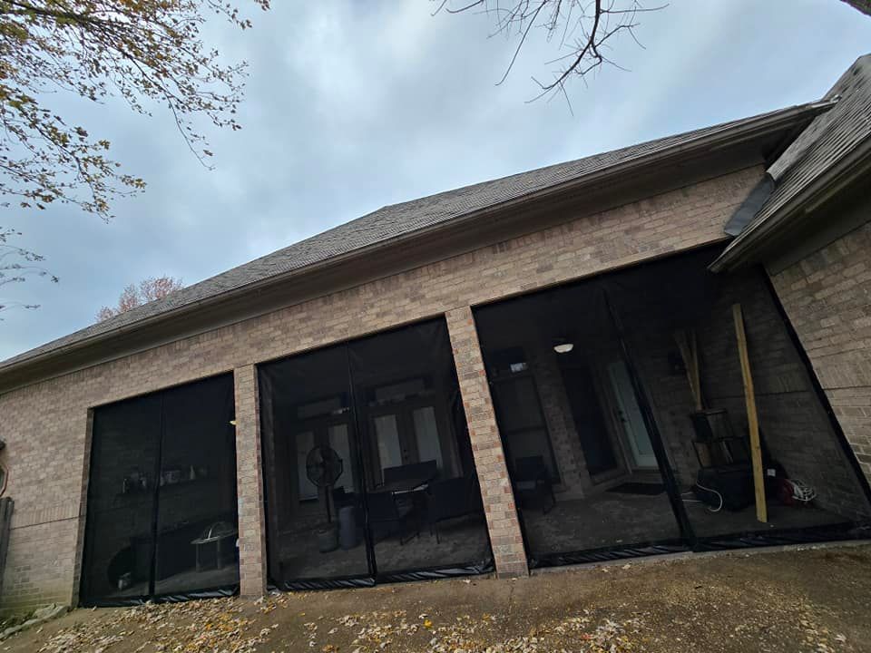 A brick house with a screened in porch and sliding glass doors.