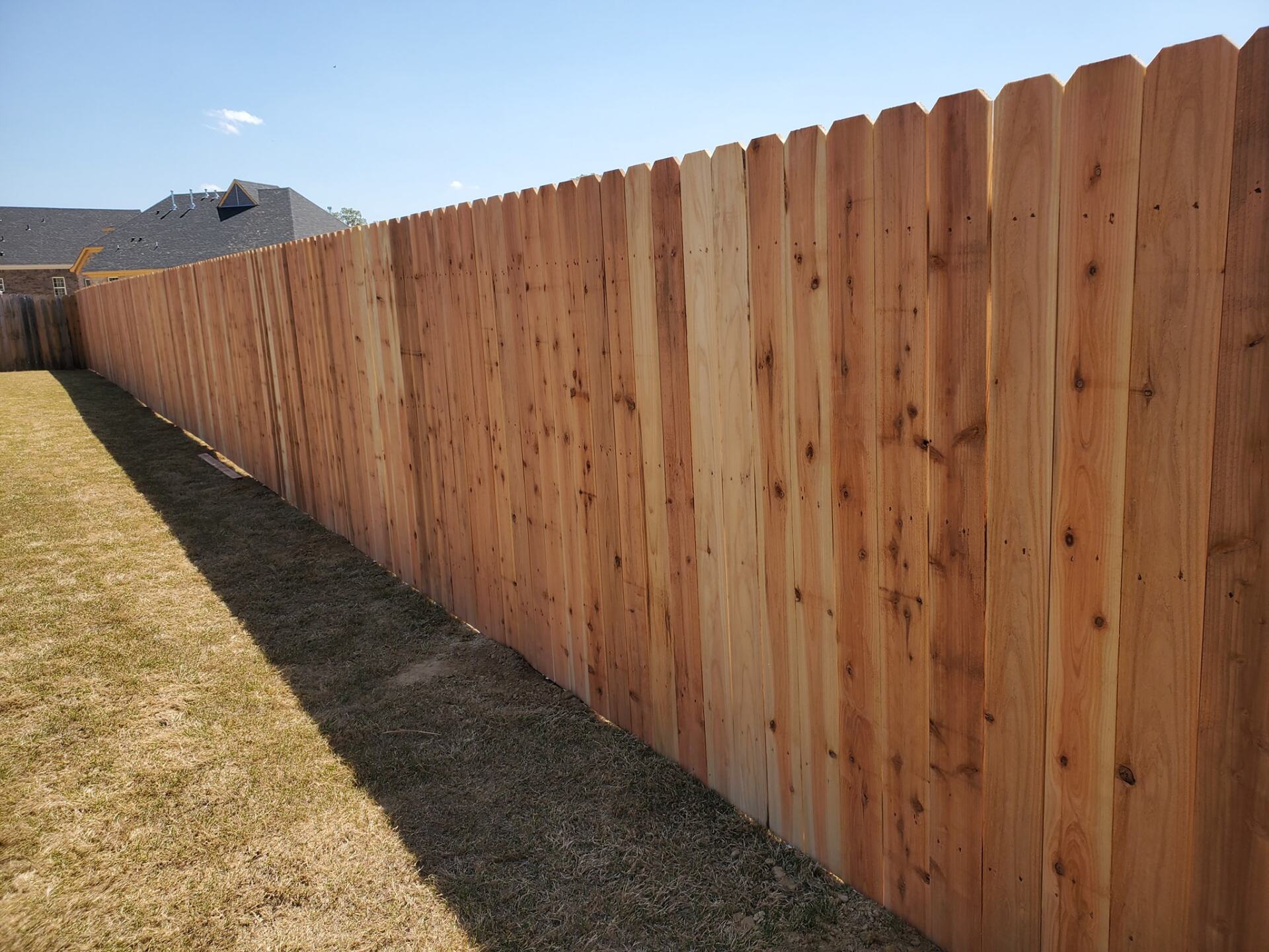 A wooden fence is sitting in the middle of a grassy yard.