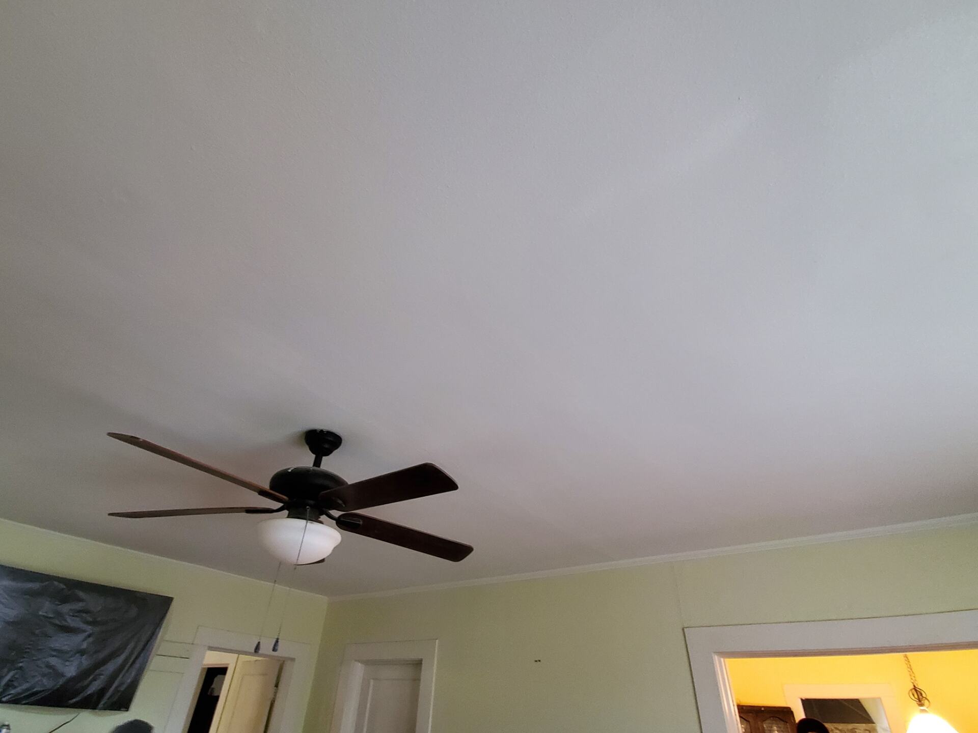 A ceiling fan is hanging from the ceiling of a room.