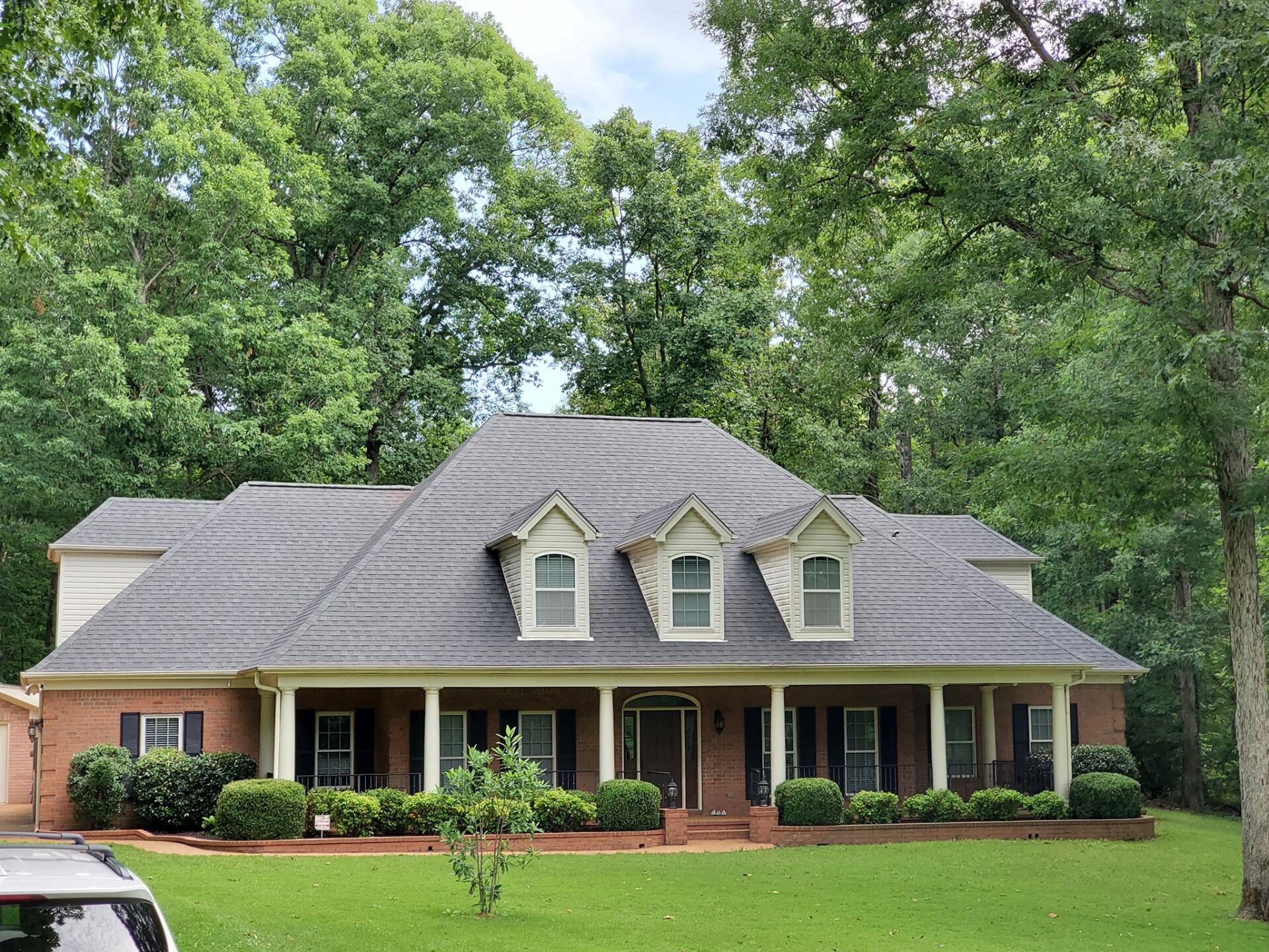 A large brick house with a car parked in front of it