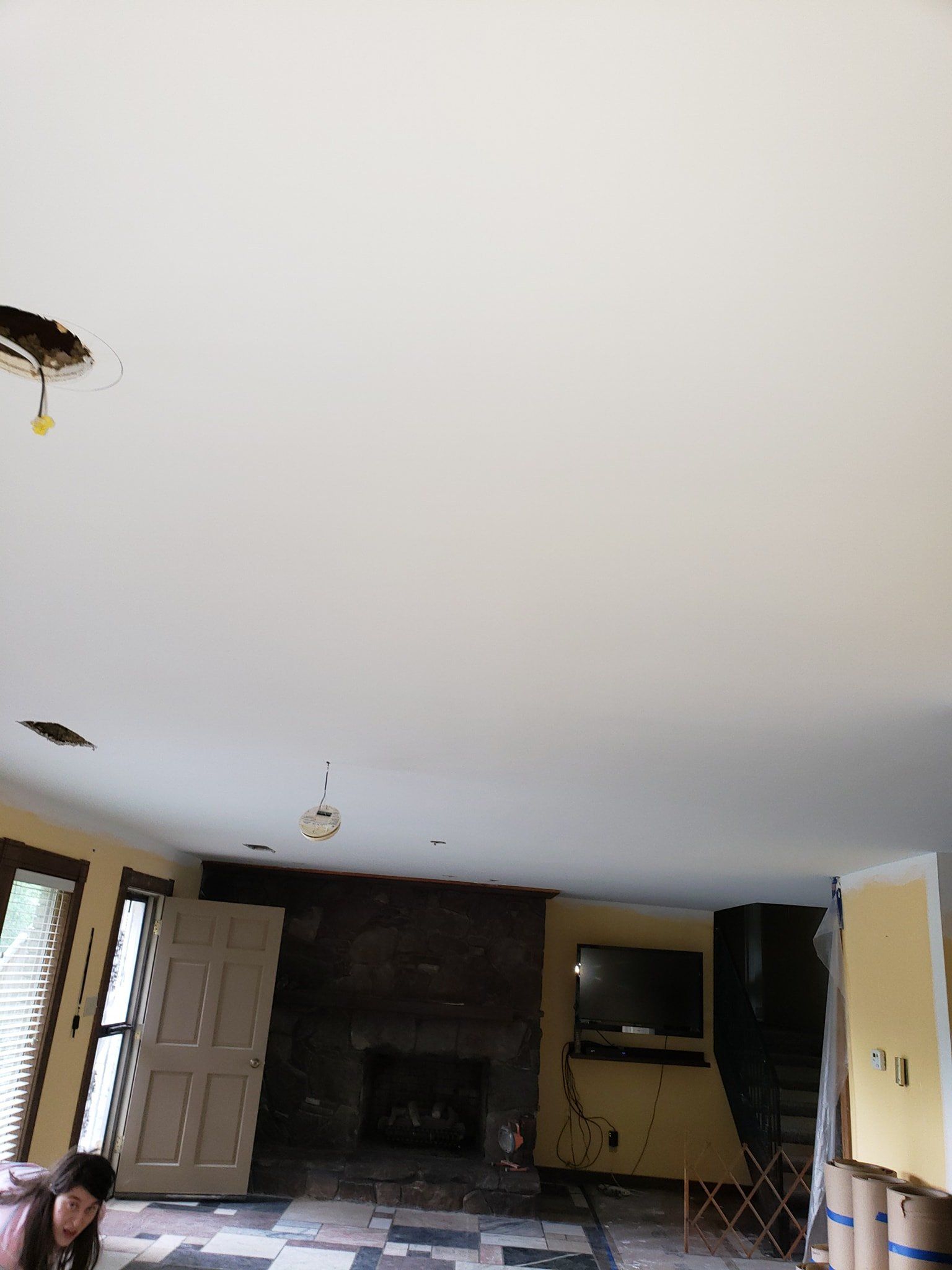 A living room with a white ceiling and a fireplace