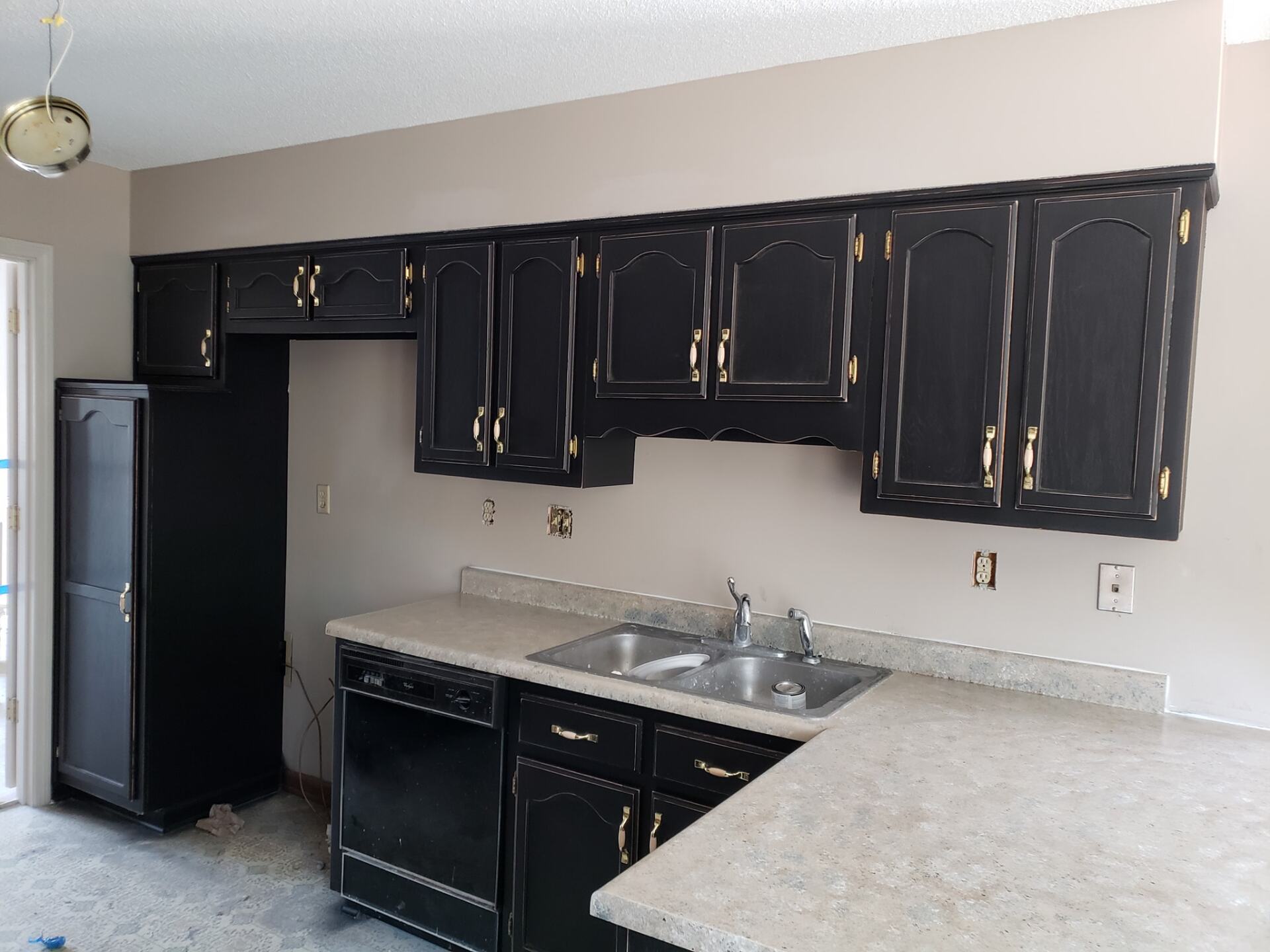 A kitchen with black cabinets and granite counter tops