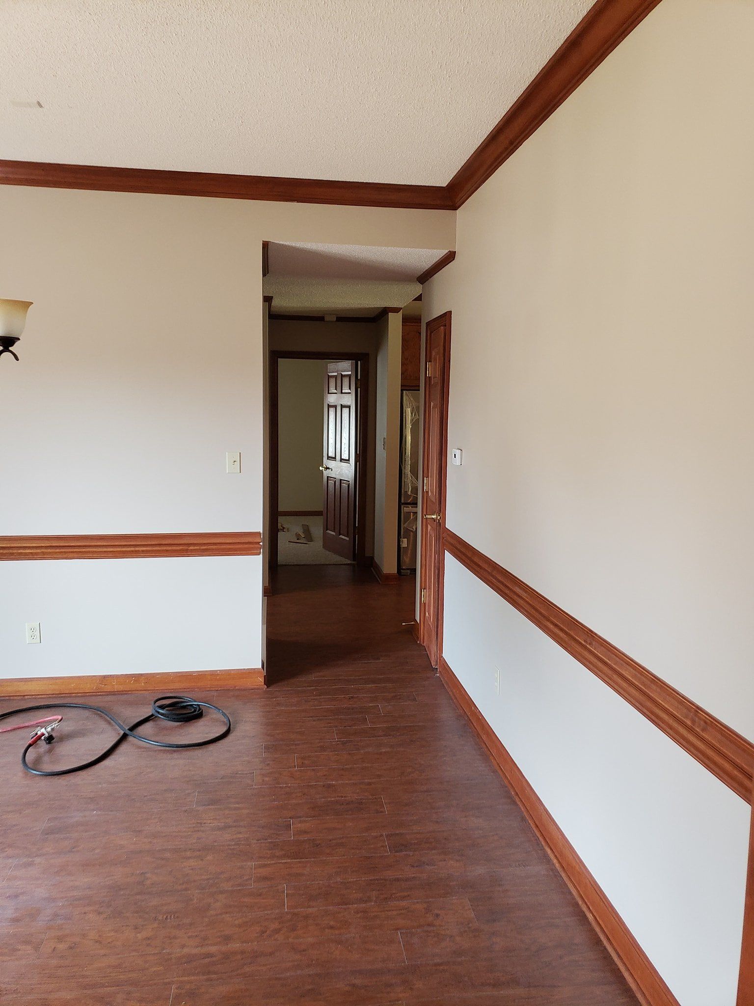 An empty living room with hardwood floors and white walls