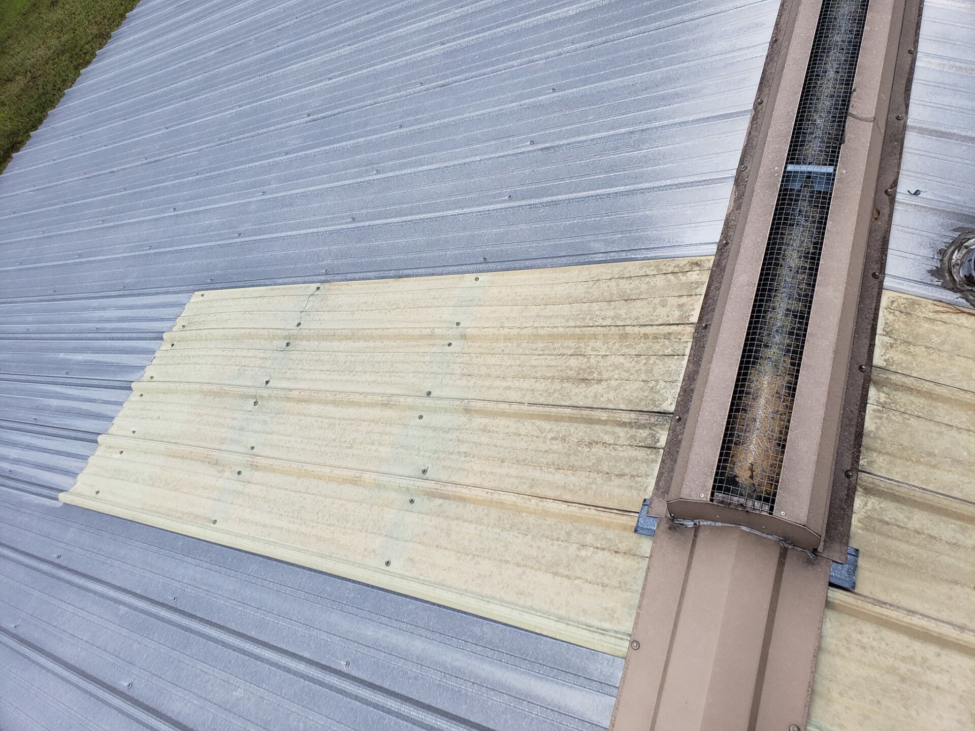 A close up of a roof with a piece of wood on it.