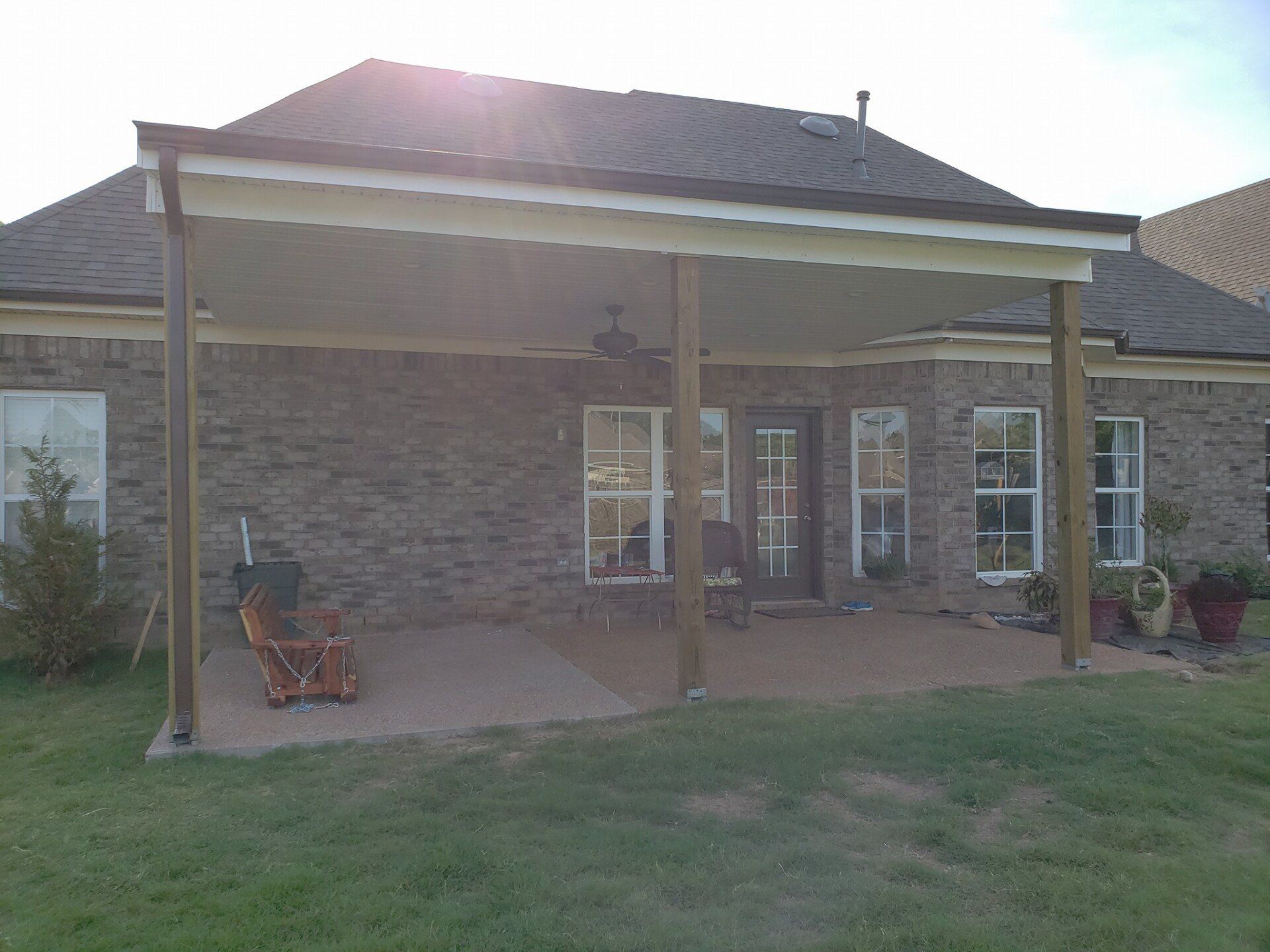 A brick house with a covered patio in front of it