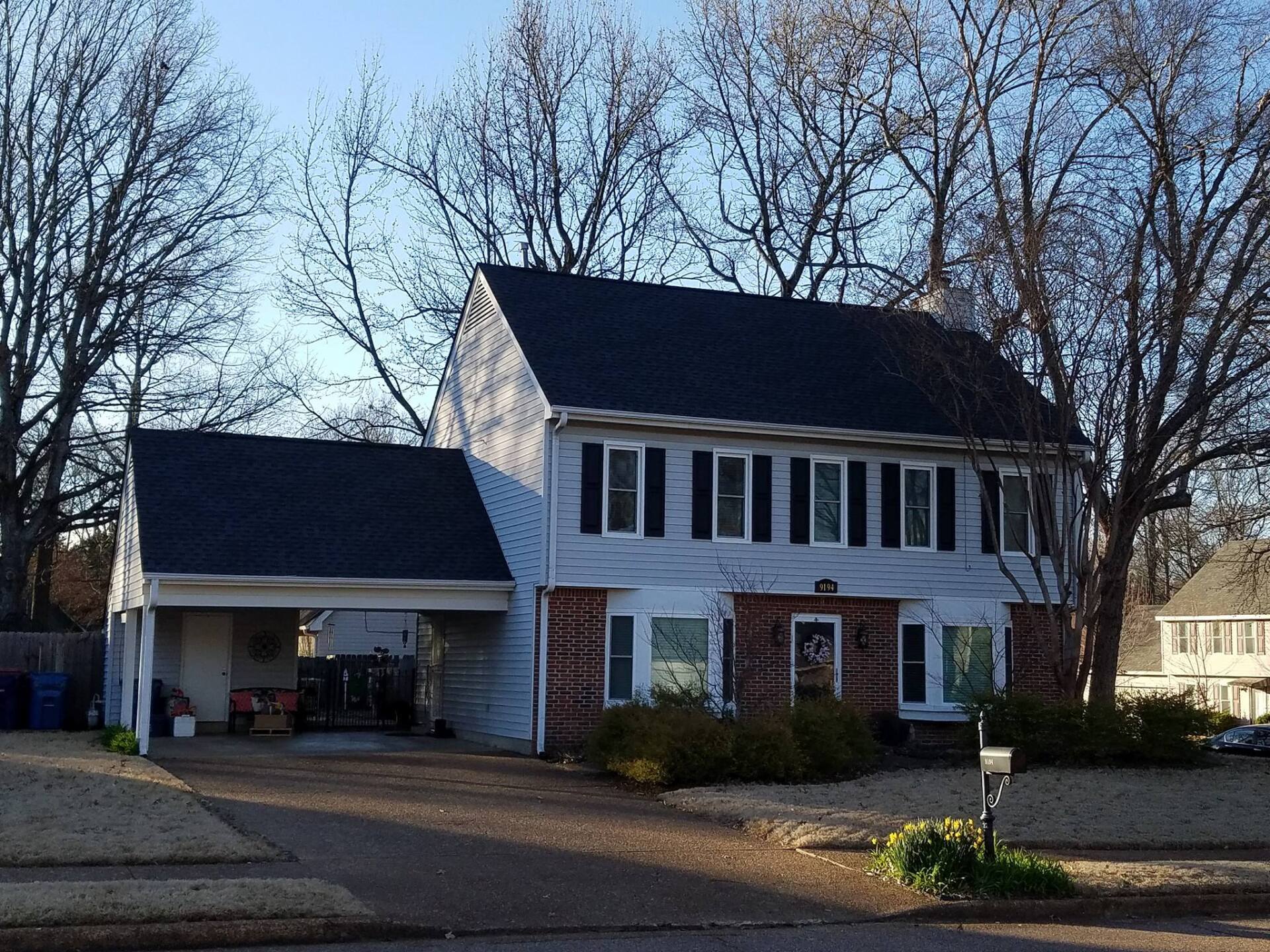 A white house with a black roof and black shutters