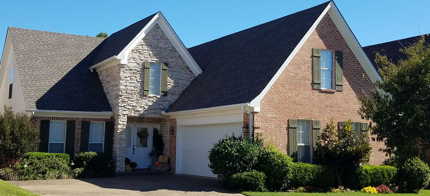 A large brick house with a black roof