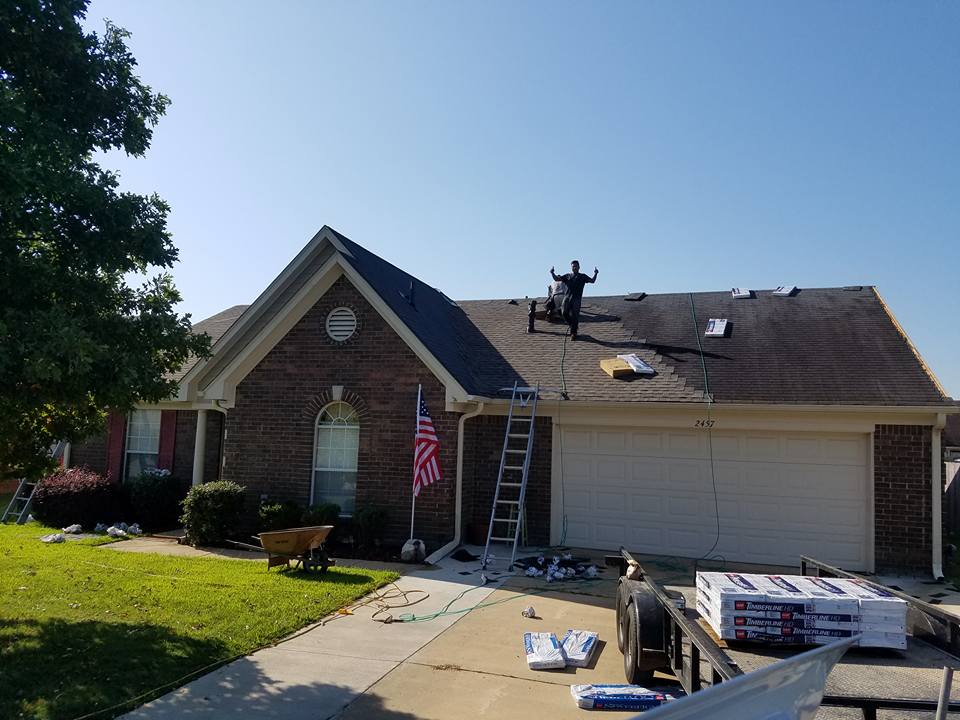 A man is working on the roof of a house.