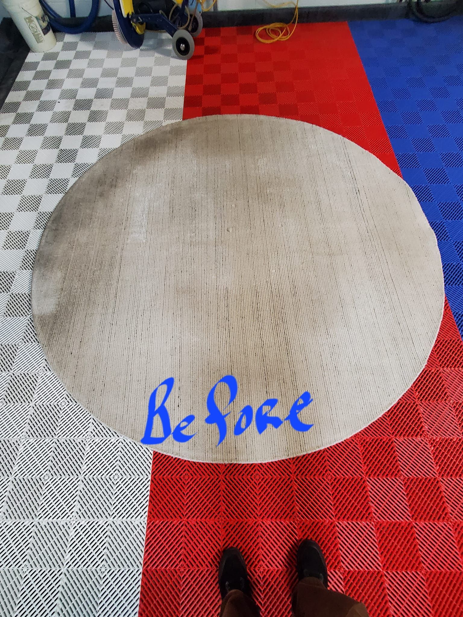 A circular, textured beige rug sits on a multi-colored tile floor, labeled 
