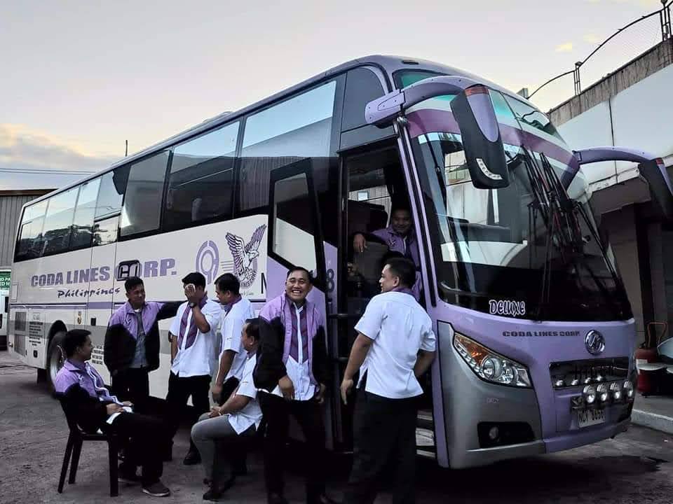 A group of people are standing in front of a bus that says food lines star