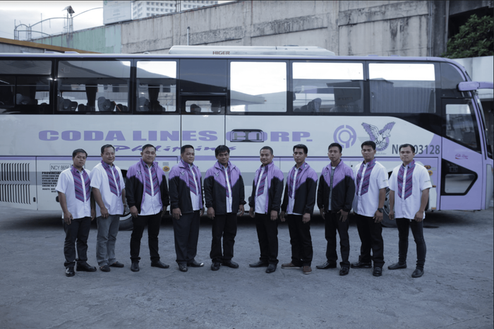A group of men are standing in front of a bus.