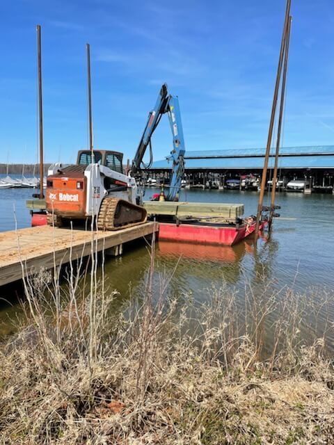 A bobcat is docked at a dock next to a body of water.