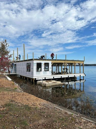 A houseboat is being built on a dock on a lake.