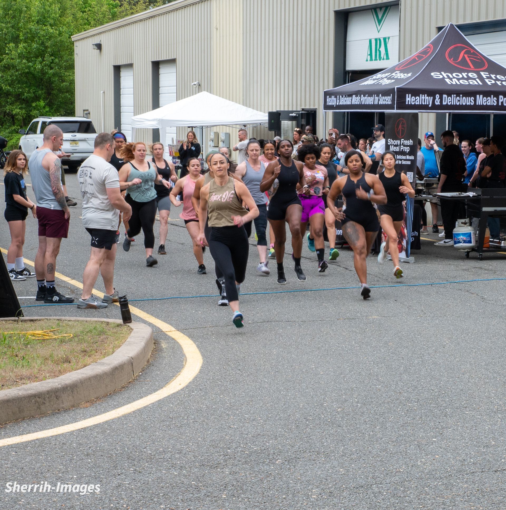 A group of people are running in front of a building that says arc