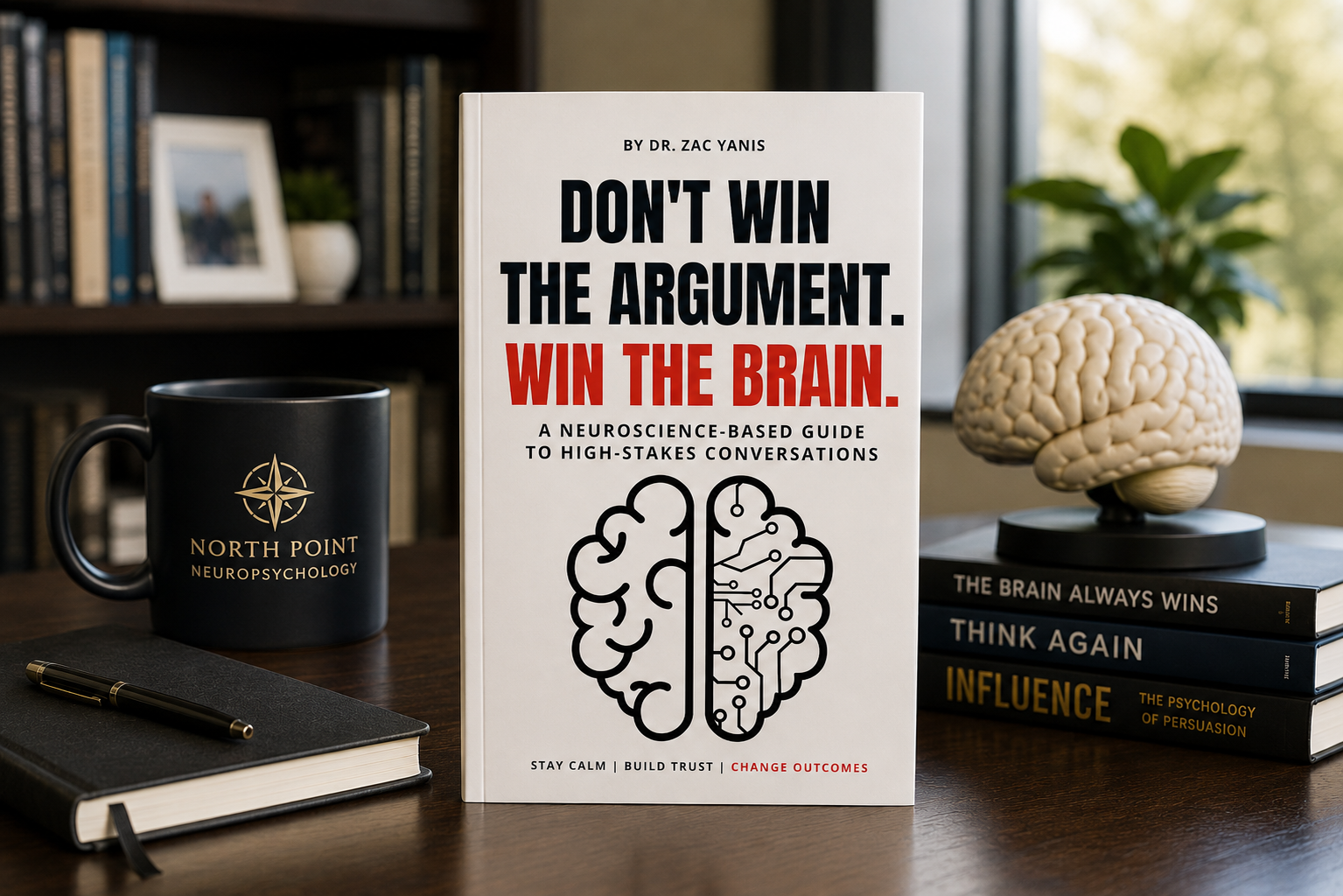 Book cover of Don't Win the Argument. Win the Brain by Dr. Zac Yanis standing on a desk beside a North Point Neuropsychology coffee mug, notebook, pen, and brain model in a modern office, representing neuroscience, communication, leadership, and learning.