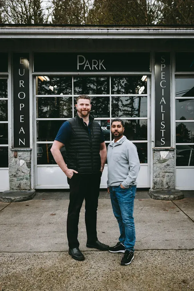 Two men standing outside a shop labeled “Park” with “European” and “Specialists” signs beside the entrance