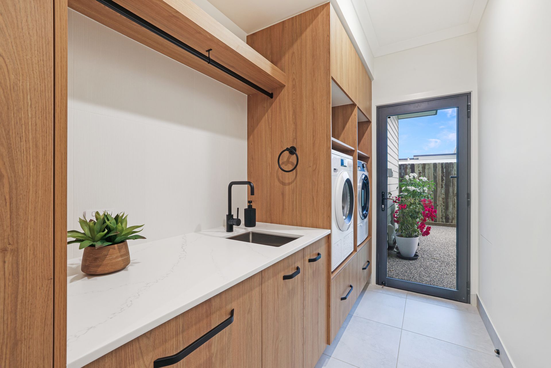 Narrow Modern Kitchenette With Wood Cabinets and Open Door to a Balcony Garden — Master Cabinets Bundaberg in Kensington, QLD