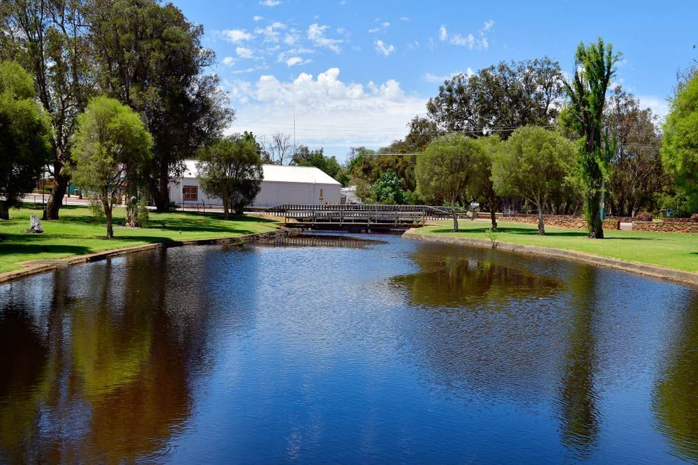 A Large Body Of Water Surrounded By Trees And Grass — Master Cabinets Bundaberg in Gin Gin, QLD