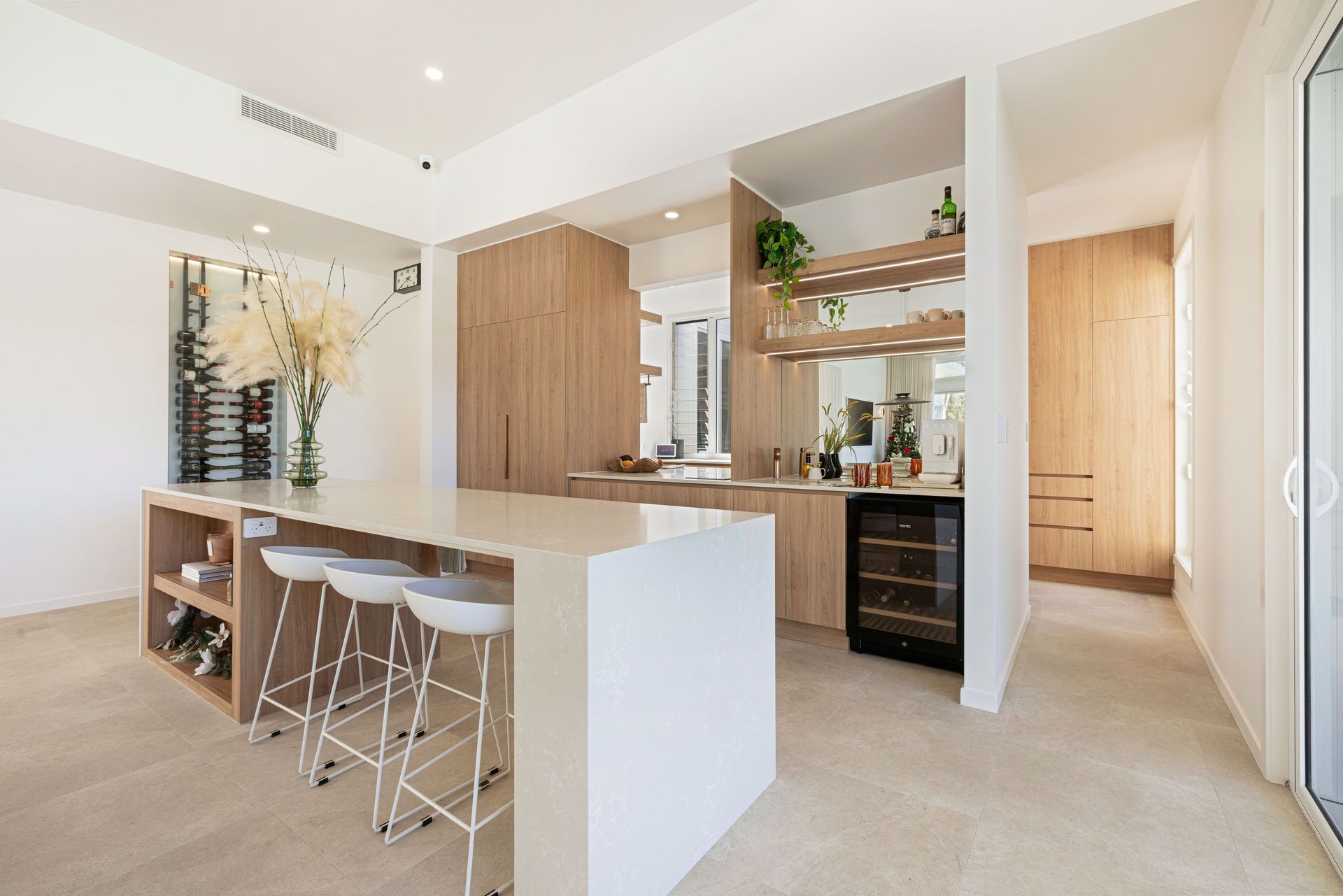 Bright Modern Kitchen With White Island, Bar Stools and Open Shelving — Master Cabinets Bundaberg in Kensington, QLD