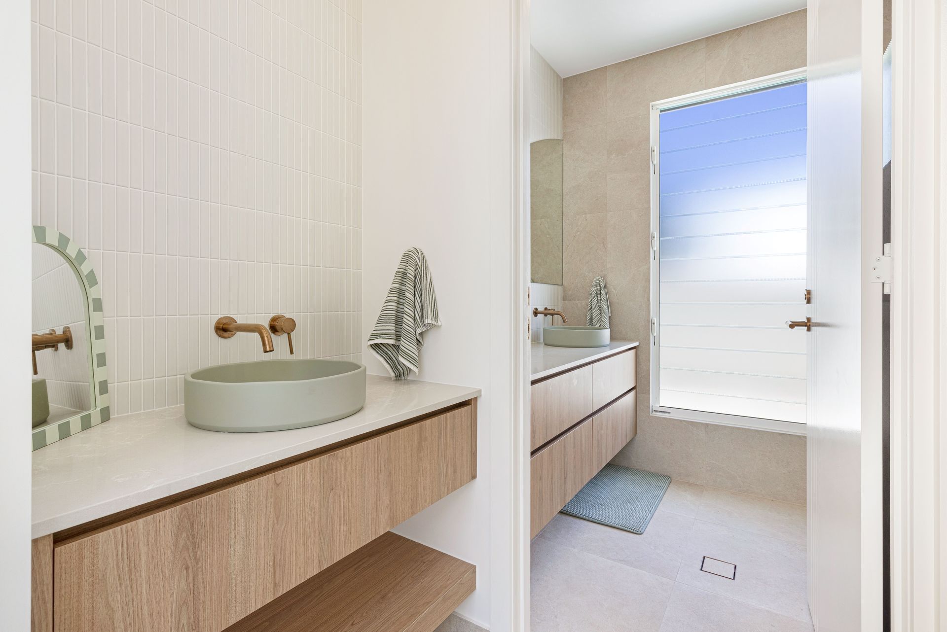 Bathroom with bathtub, sink, and large window. Two hanging pendant lights above.