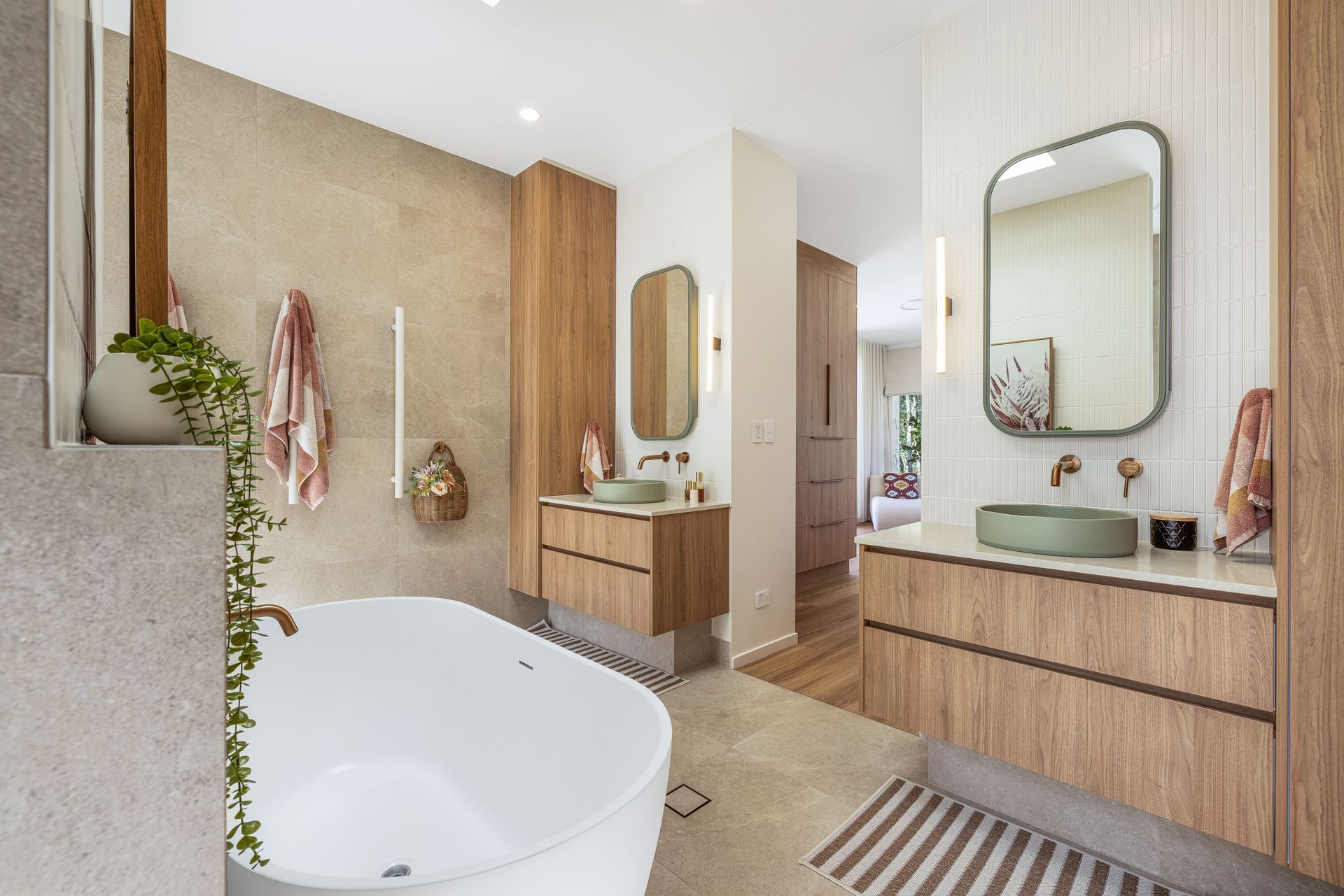 Modern Bathroom With a Freestanding Tub, Double Vanity and Striped Rug — Master Cabinets Bundaberg in Kensington, QLD