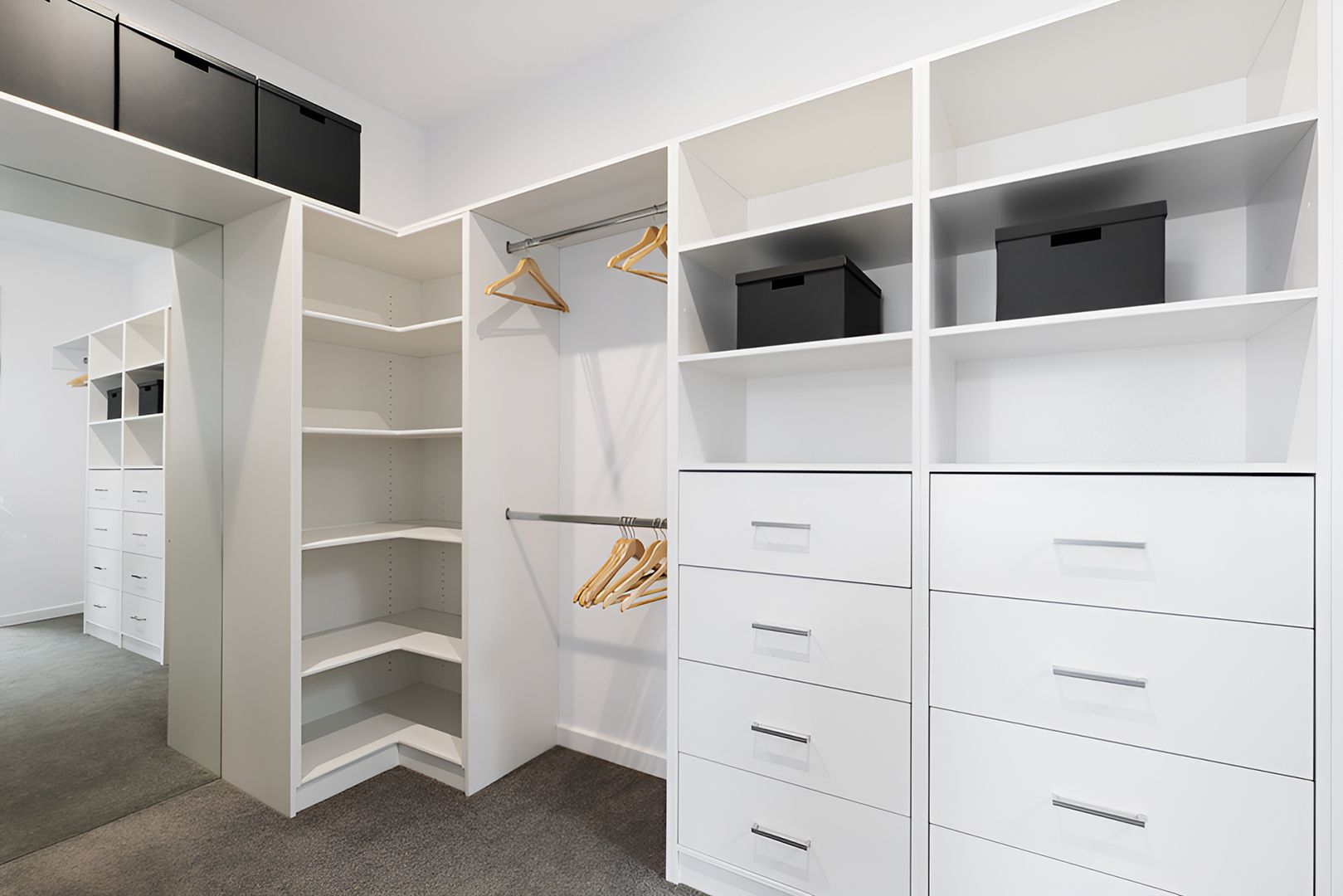 A White Wardrobe With The Doors Open In An Empty Room — Master Cabinets Bundaberg in Burrum Heads, QLD