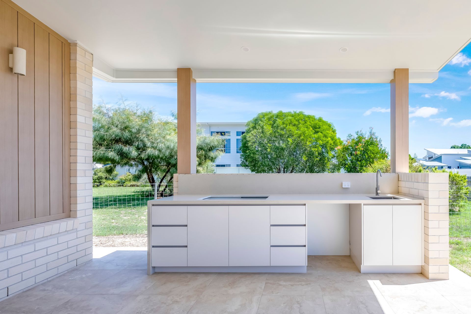 A White House With A Large Swimming Pool In Front Of It — Master Cabinets Bundaberg in Kensington, QLD