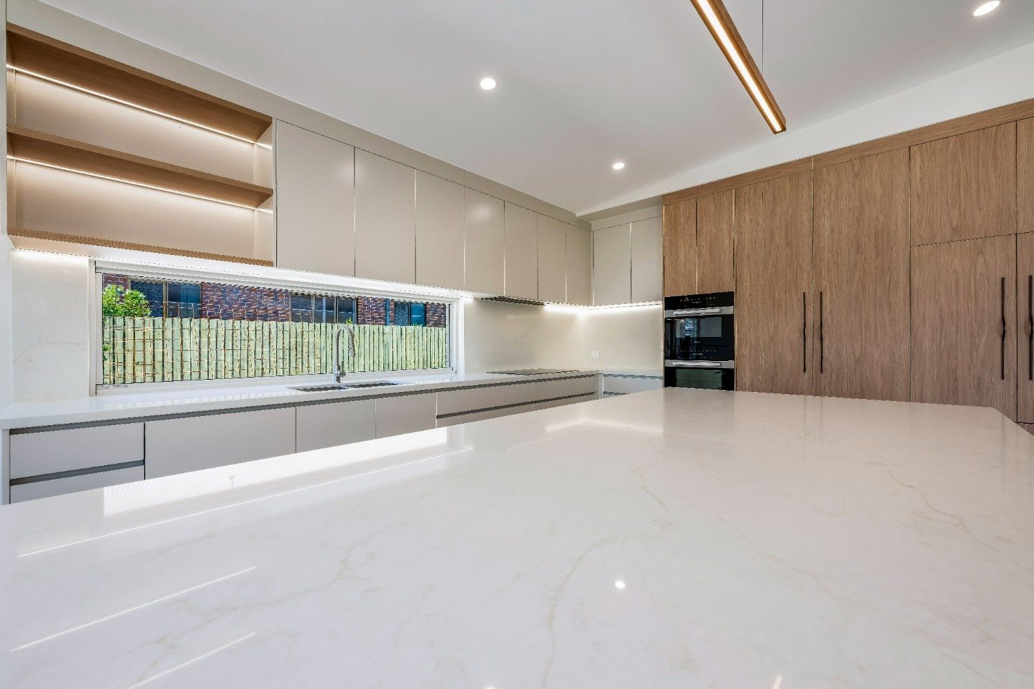 White and Black Modern Kitchen With Stove, Cabinets, and Appliances — Master Cabinets Bundaberg in Kensington, QLD