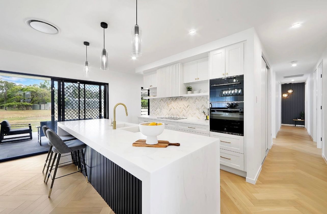 A Kitchen With A Large Island And A Ceiling Fan — Master Cabinets Bundaberg in Burrum Heads, QLD