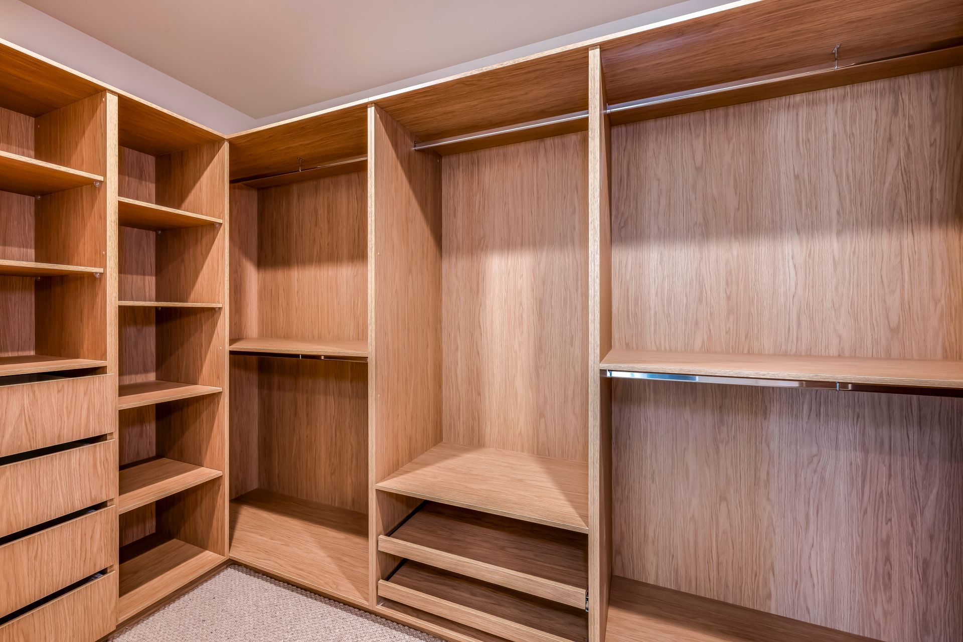 Walk-in wooden closet with shelves, and built-in drawers.