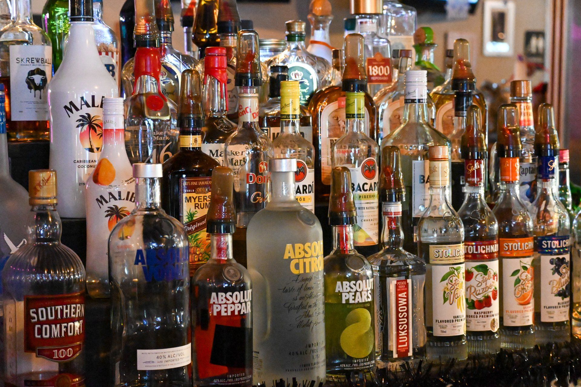 A bar filled with bottles of alcohol including absolut vodka