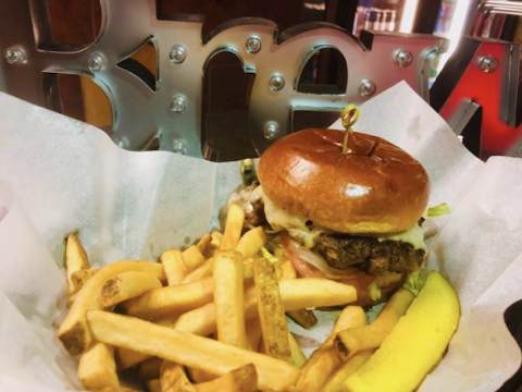 A hamburger with french fries and a pickle in a basket