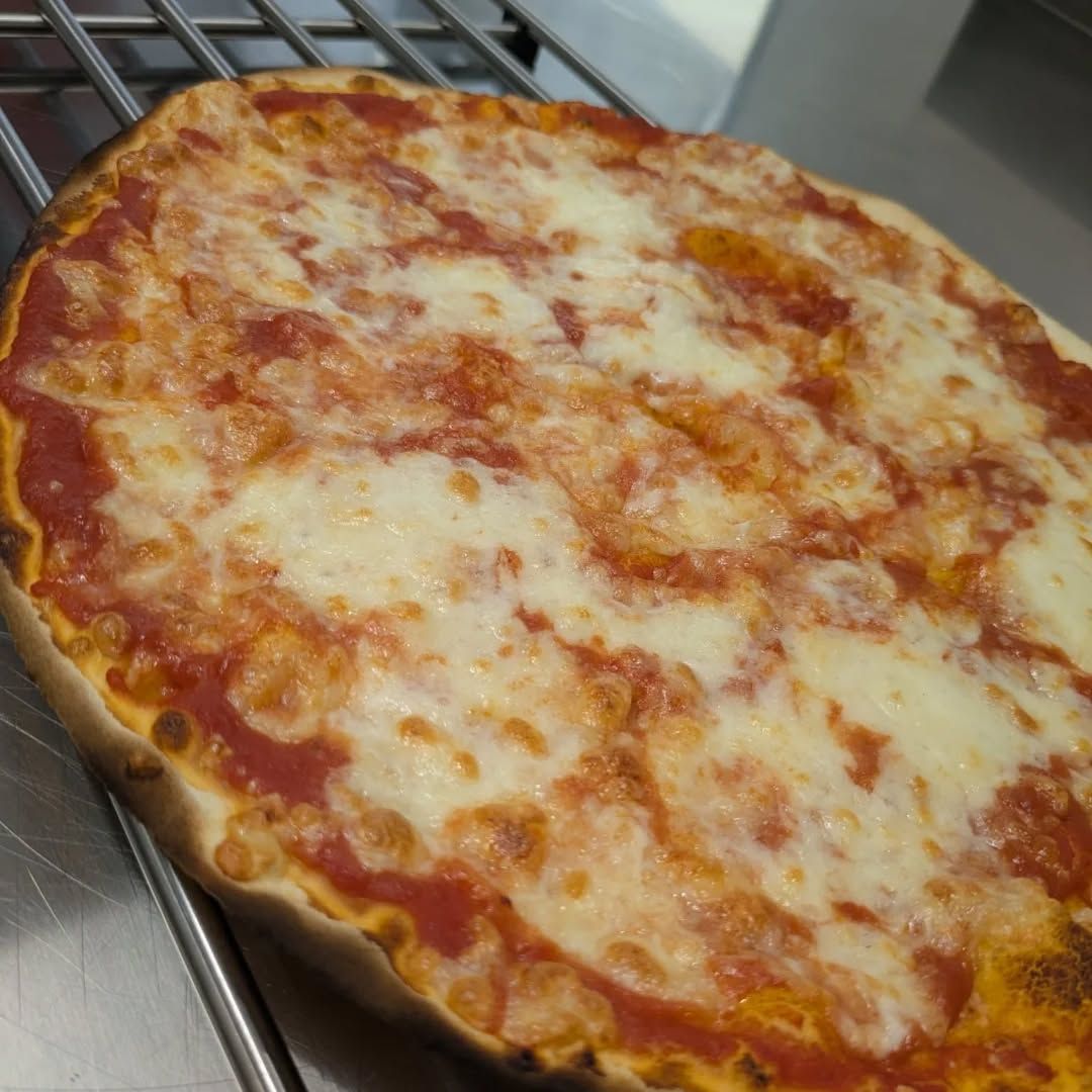Pizza con salsa di pomodoro e formaggio fuso su una griglia.