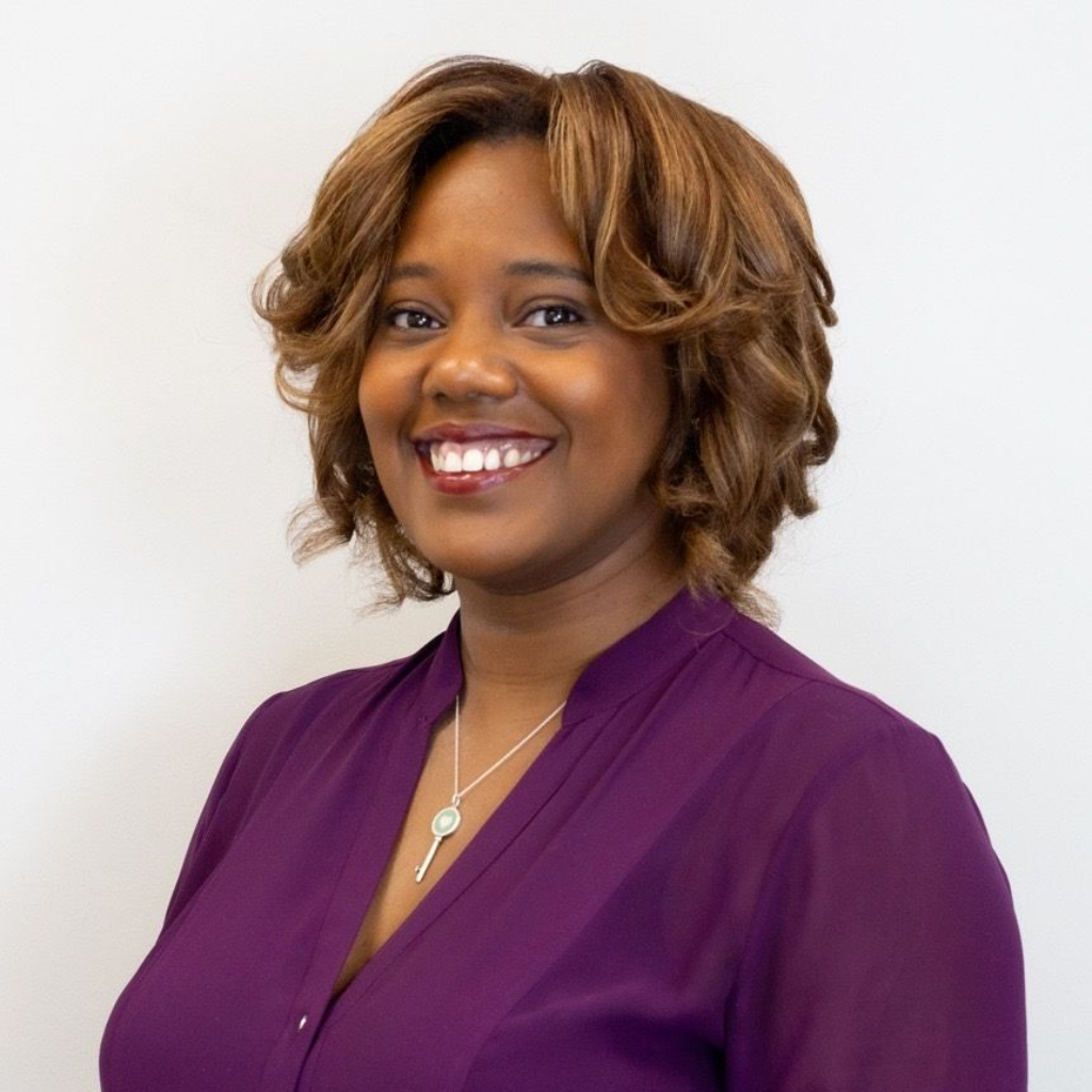 Portrait of a smiling person in a purple blouse against a white background