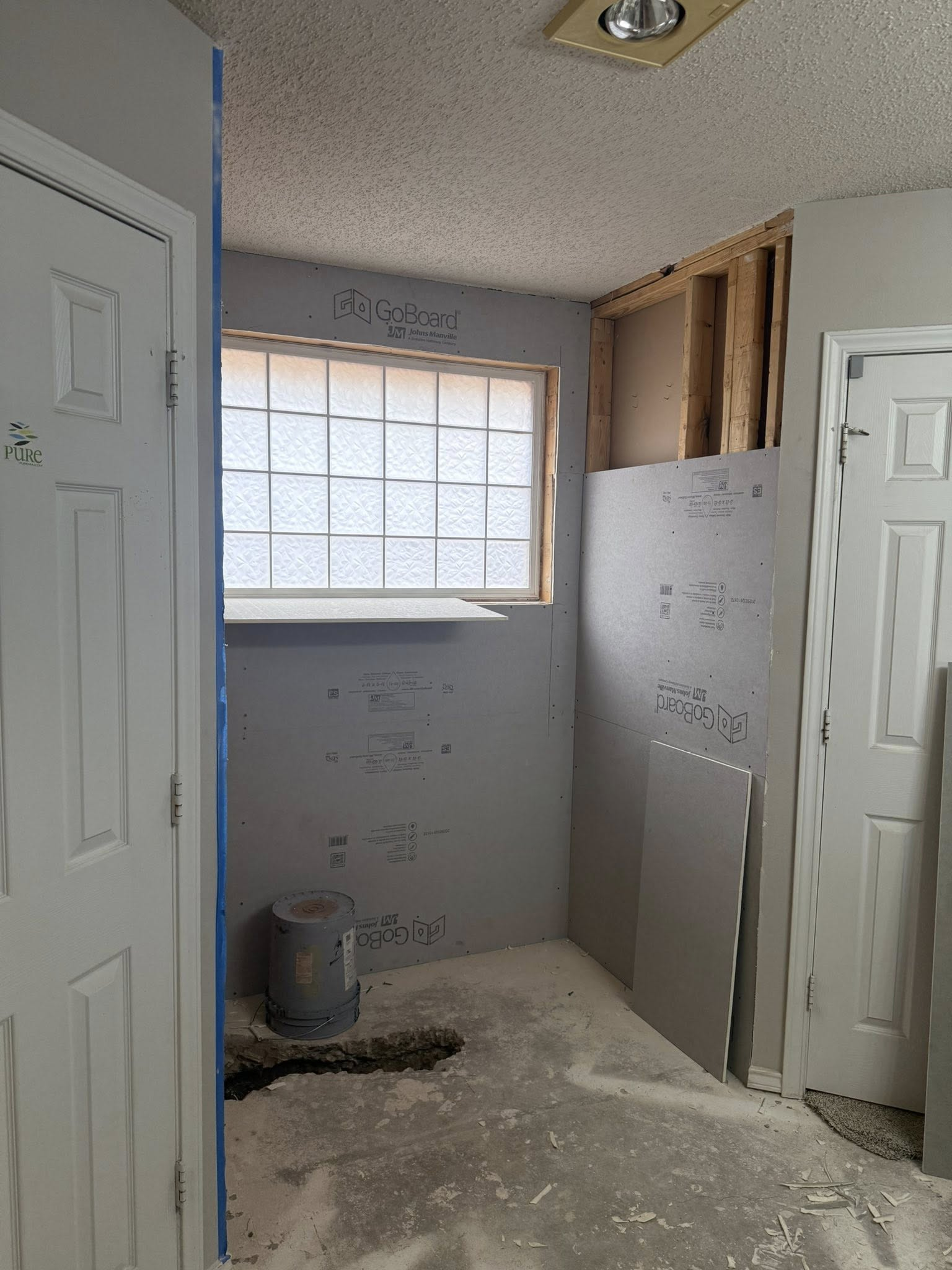 Bathroom under construction with drywall, window, and door frames.