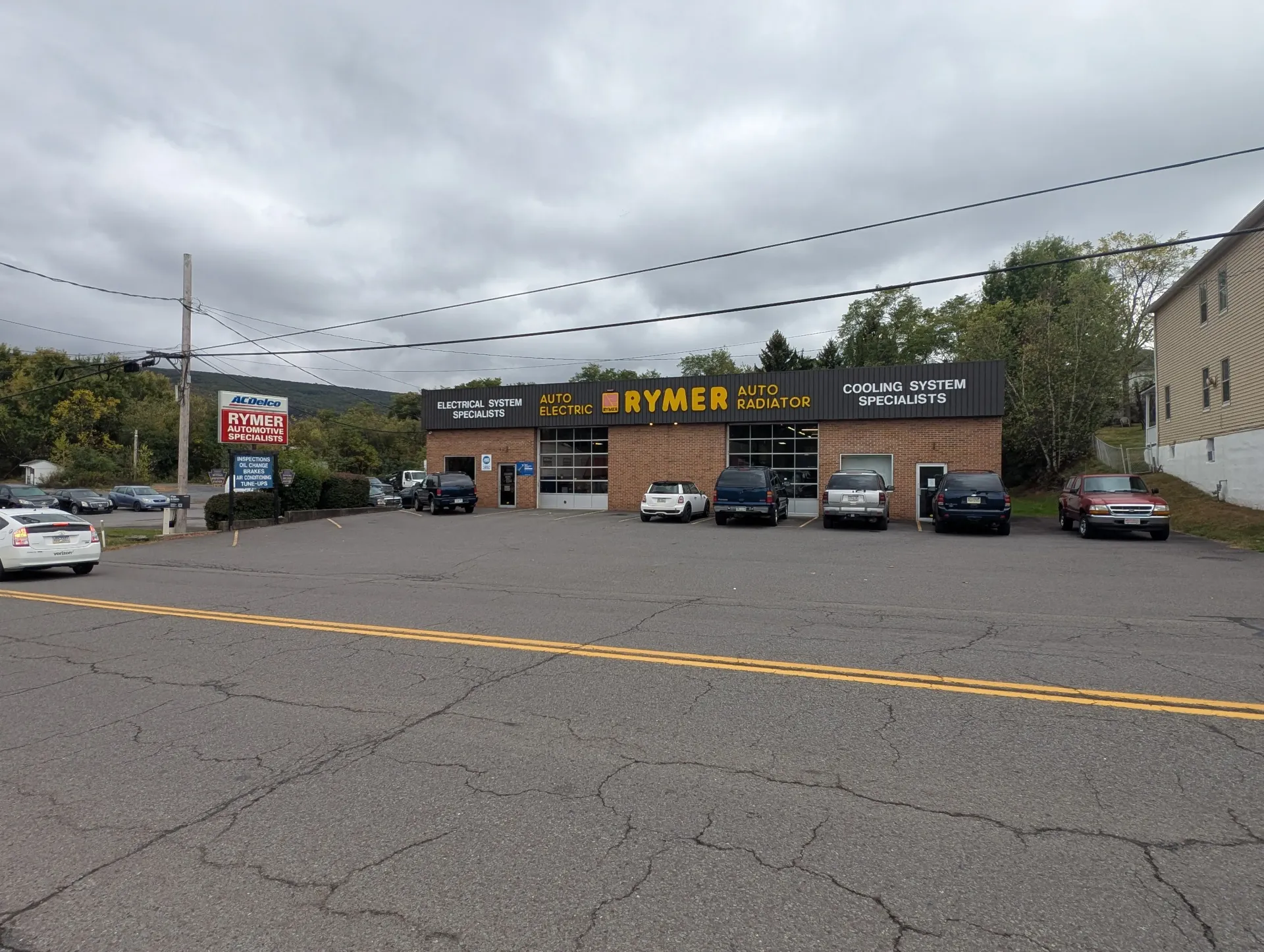 Exterior of a car repair shop with several vehicles parked in front | Rymer Automotive