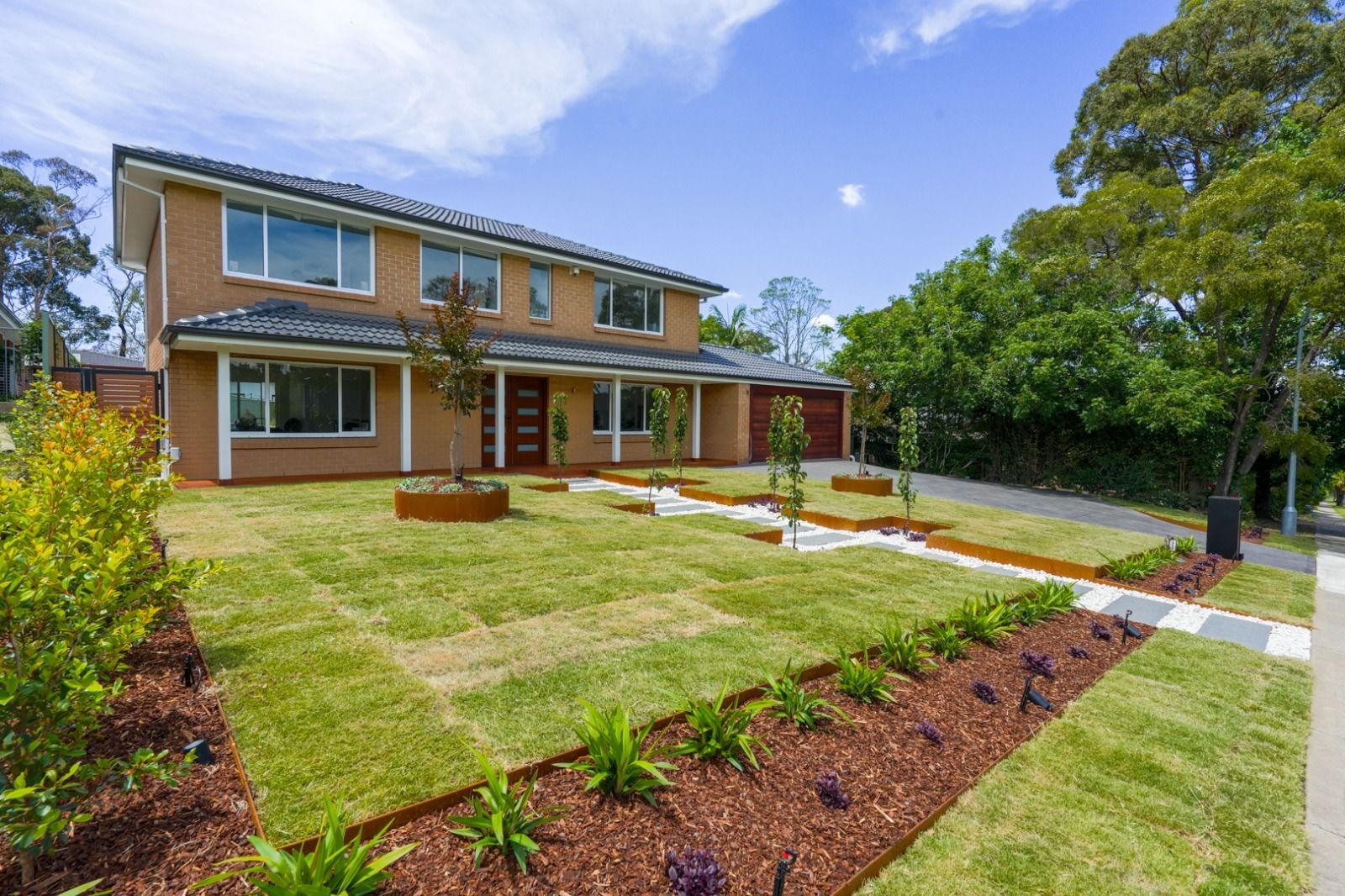 A large brick house with a lush green lawn in front of it.
