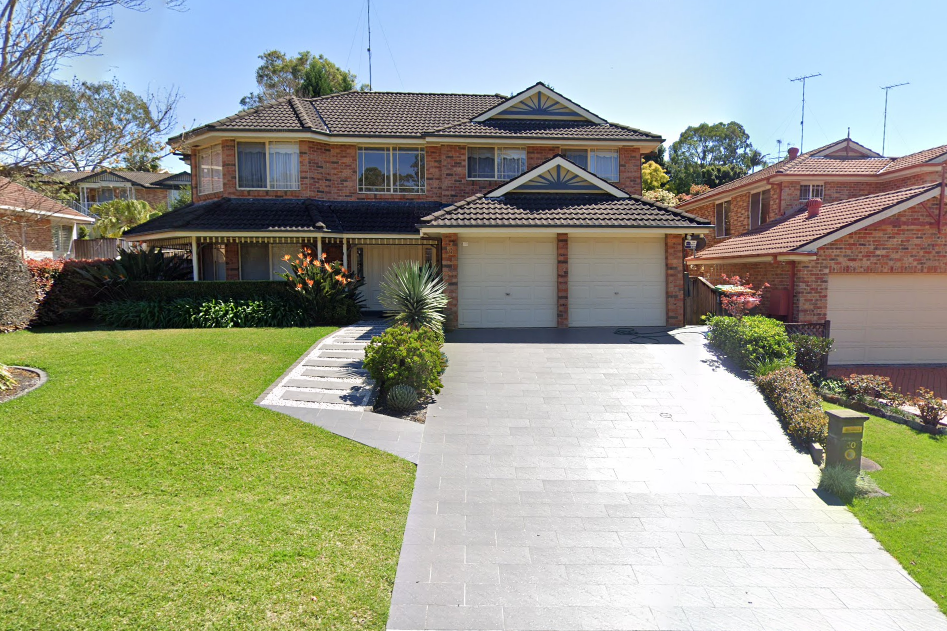 A large brick house with two garages and a driveway