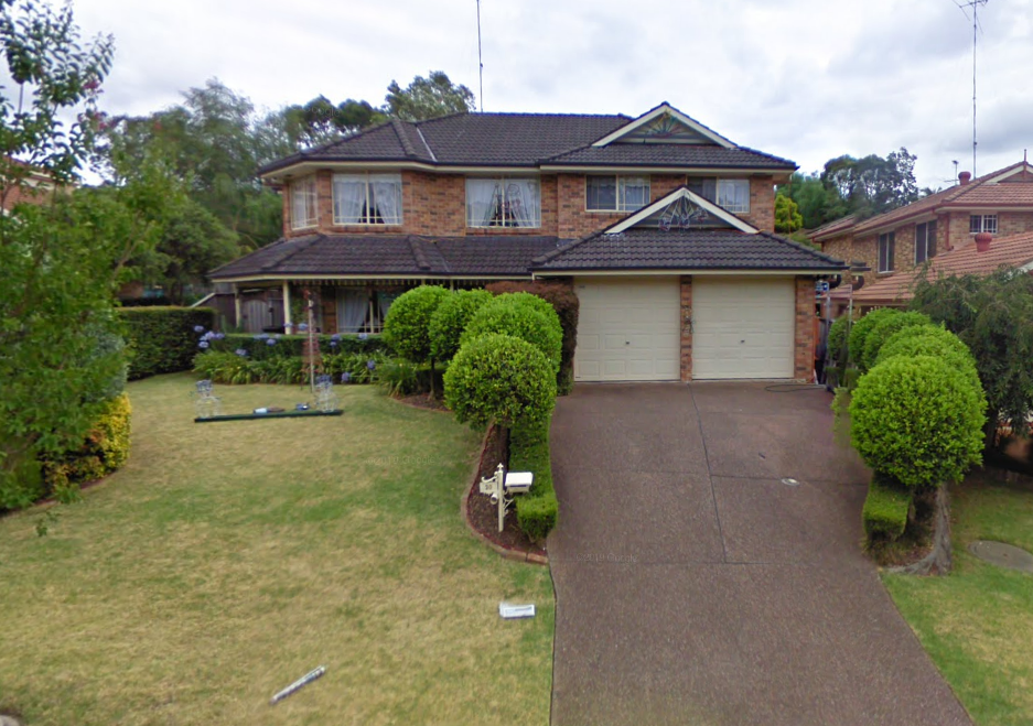 A large brick house with two garages and a driveway